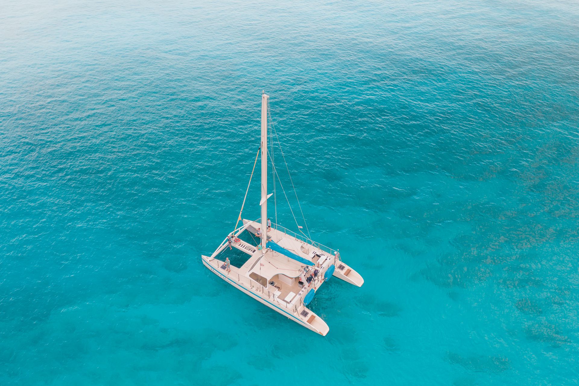 Vista aérea de un catamarán navegando en aguas turquesa